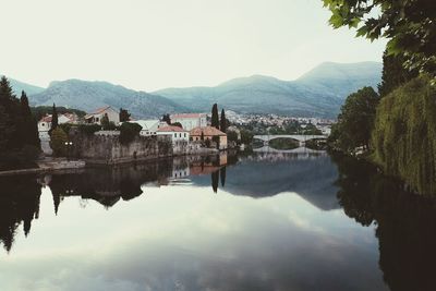 Scenic view of lake by buildings against sky