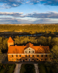 Building by mountain against sky during sunset