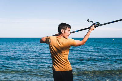 Man standing by sea against sky