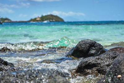 Surface level of rocks on beach against sky