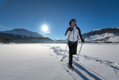 Man standing on snowcapped mountain against sky