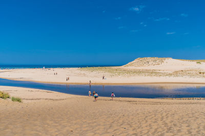 High angle view of people on beach against blue sky