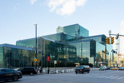 Traffic on road by buildings against sky