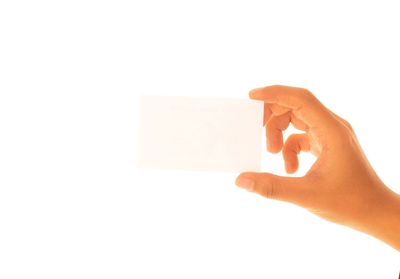 Close-up of hand holding paper against white background