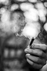 Close-up of hand holding cigarette