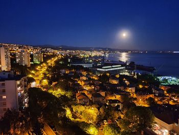 High angle view of illuminated buildings against sky at night