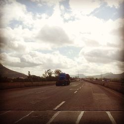 Empty road against cloudy sky