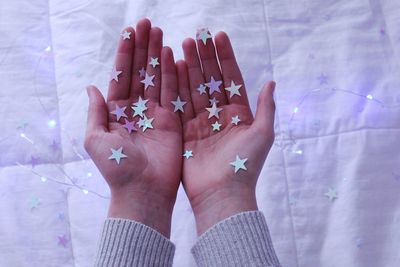 Cropped image of woman holding star shaped decoration