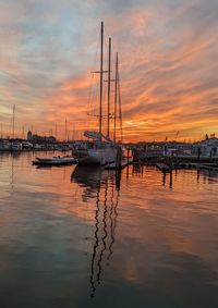 Boats in harbor during sunset