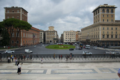 Group of people on road against buildings in city