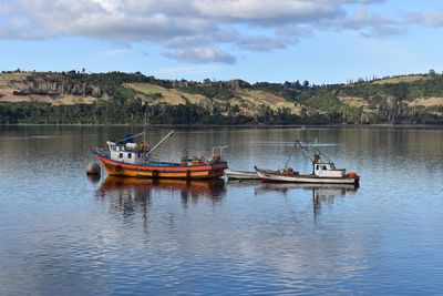 Fishing boat in lake against sky