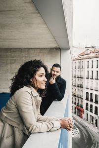 Side view of young couple looking at camera