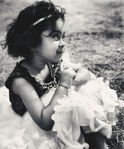 Close-up of cute girl sitting on field