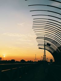 Road passing through city during sunset