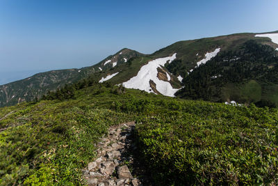 Scenic view of mountains against clear blue sky