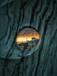 Buildings seen through hole during sunset