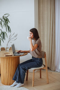 Young woman working remotely at home using a laptop