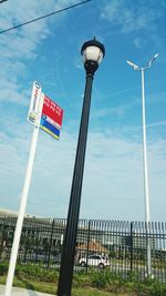 Low angle view of road sign against blue sky