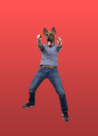 Portrait of man jumping against red background