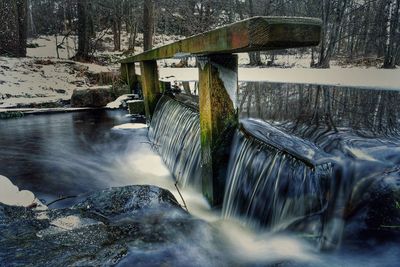 Scenic view of waterfall by river in forest