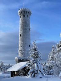 Tower on snow covered building against sky