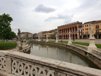 Arch bridge over river against buildings in city