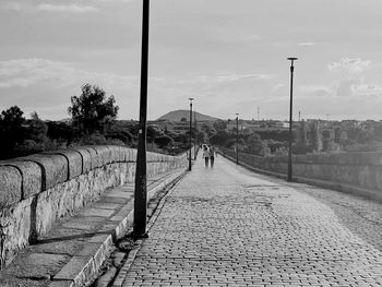 Rear view of man walking on footpath