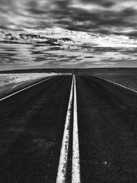 Surface level of road against cloudy sky