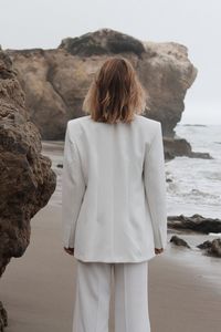 Rear view of woman standing at beach