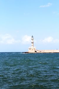 Lighthouse by sea against sky