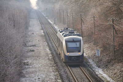 High angle view of passenger train amidst trees in frosty winter