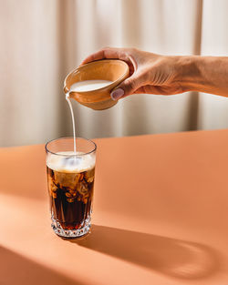 A person pouring milk into coffee