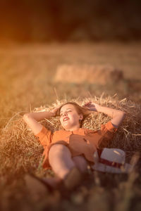 Portrait of woman lying down on field