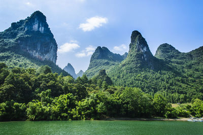 Scenic view of green landscape and mountains against sky