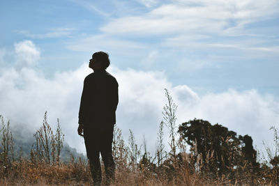 Rear view of silhouette man standing on mountain