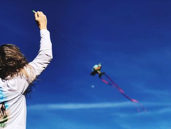 Rear view of man and woman against blue sky