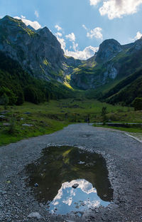 Scenic view of lake by mountains against sky