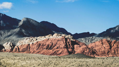 Scenic view of mountains against blue sky