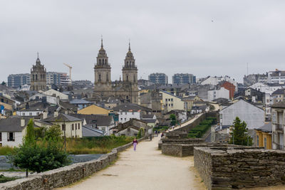 View of buildings in town against sky from the wall of lugo