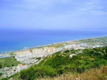 Scenic view of sea by buildings against sky