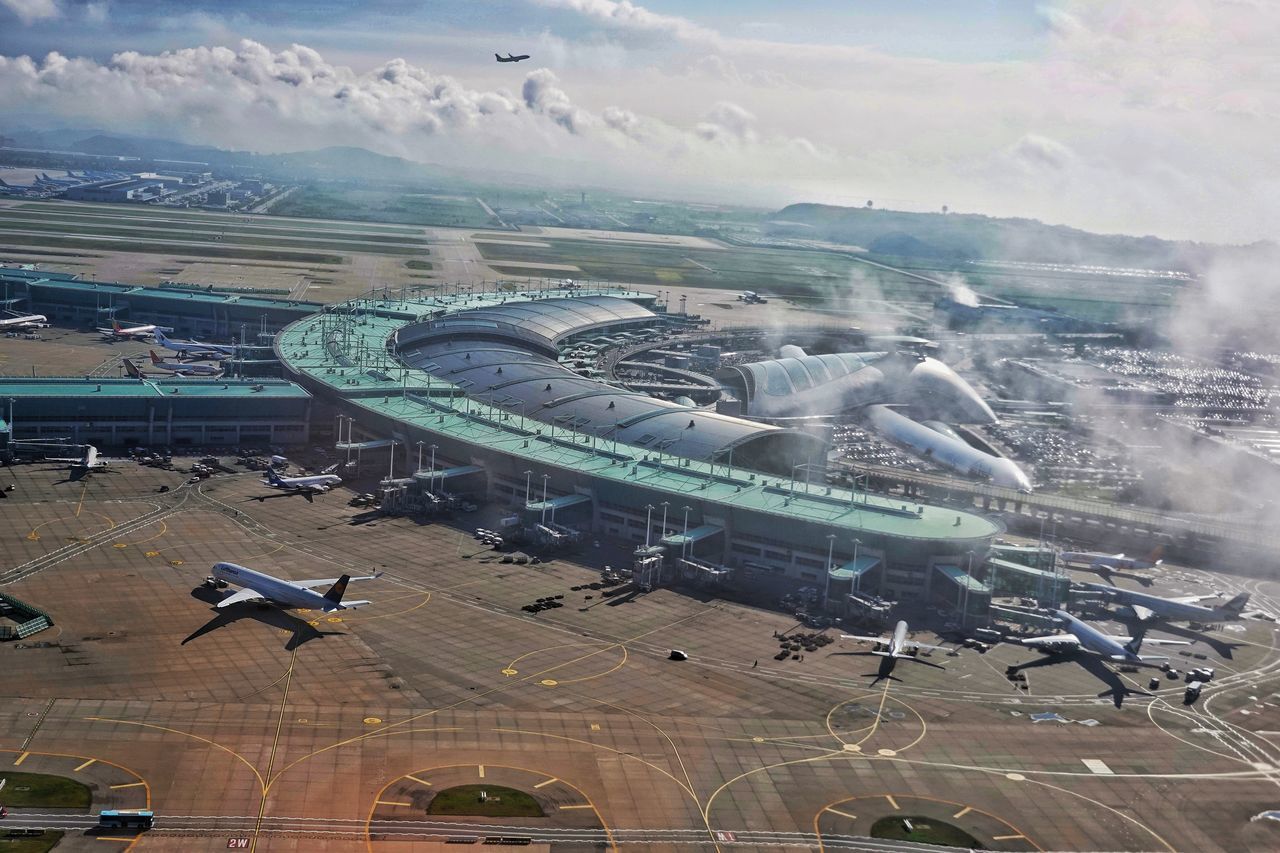 HIGH ANGLE VIEW OF AIRPLANE FLYING IN AIRPORT