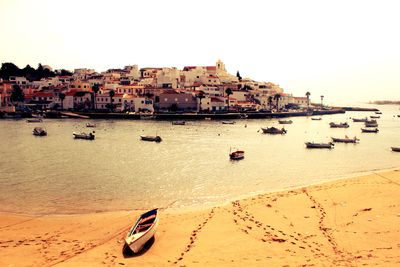 Boats in river with buildings in background