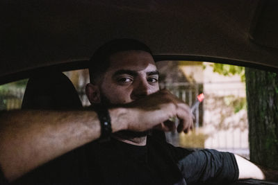 Portrait of young man sitting in car