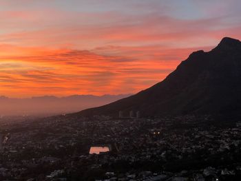 Scenic view of silhouette mountains against orange sky