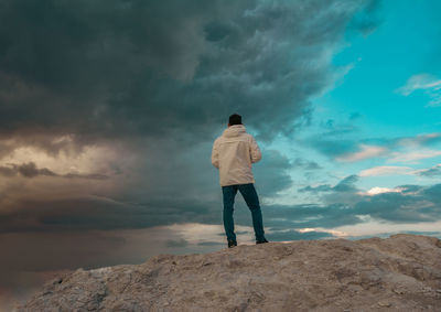 Rear view of man standing on rock