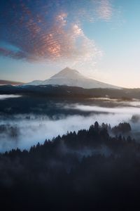 Scenic view of mountains against cloudy sky during sunset