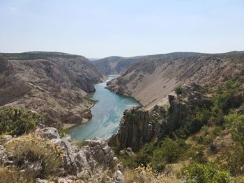 High angle view of river amidst mountains against sky