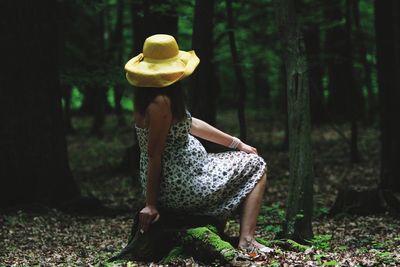 Full length of woman sitting in forest