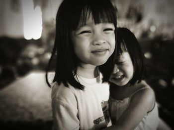 Portrait of cute girl embracing sister at home