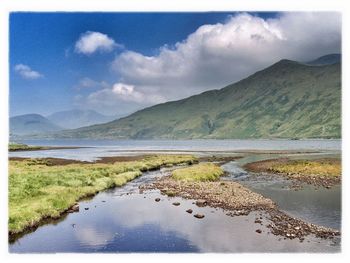 Scenic view of lake against cloudy sky